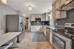 Kitchen featuring decorative light fixtures, backsplash, appliances with stainless steel finishes