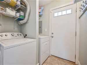 Laundry room with separate washer and dryer side door to driveway and garage