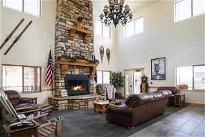 Living room featuring a fireplace, a wealth of natural light, and a towering ceiling