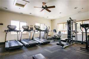 Workout area with dark colored carpet and ceiling fan