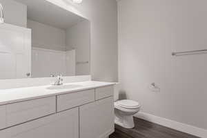 Bathroom with vanity, hardwood / wood-style floors, toilet, and walk in shower