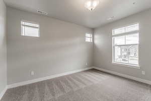 Carpeted empty room featuring a textured ceiling