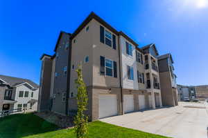 Exterior space featuring a garage and a lawn