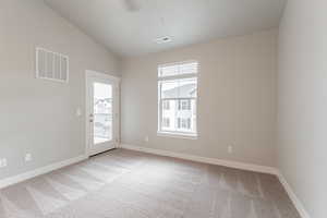 Spare room with vaulted ceiling and light colored carpet