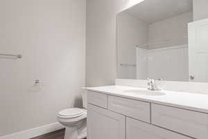 Bathroom with walk in shower, vanity, toilet, and hardwood / wood-style flooring