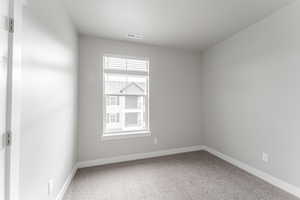 Carpeted spare room featuring a textured ceiling