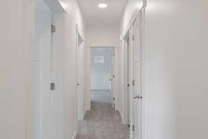 Corridor featuring light carpet