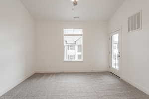 Carpeted spare room featuring ceiling fan