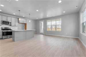 Kitchen featuring plenty of natural light, light wood-type flooring, and stainless steel appliances