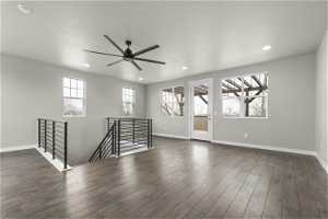 Spare room featuring dark hardwood / wood-style floors, ceiling fan, and a wealth of natural light