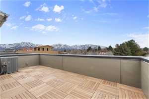 Wooden terrace with a mountain view and central AC unit