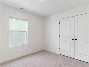 Unfurnished room with light colored carpet and a healthy amount of sunlight