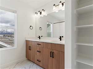 Bathroom featuring tile floors and double vanity