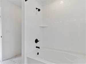 Bathroom featuring tiled shower / bath combo and tile floors