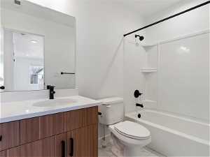 Full bathroom featuring bathtub / shower combination, toilet, vanity, and tile flooring