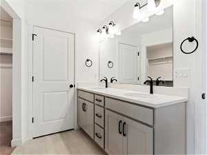 Bathroom featuring double sink, vanity with extensive cabinet space, and tile flooring