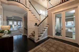 Staircase with dark hardwood / wood-style flooring, a high ceiling, and french doors