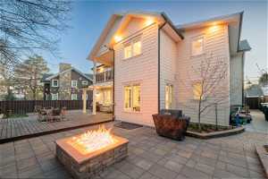 Rear view of house featuring an outdoor fire pit and a balcony