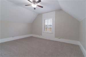 Additional living space with carpet, vaulted ceiling, and ceiling fan