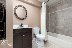 Full bathroom featuring toilet, vanity, shower / tub combo with curtain, and tile flooring