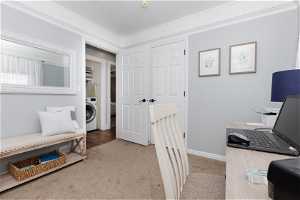 Carpeted office space with washer / clothes dryer and crown molding