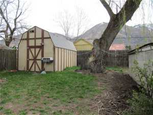 View of back yard featuring a mountain view and a storage unit