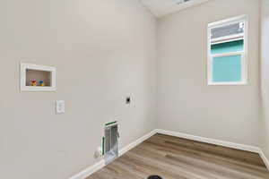 Washroom with electric dryer hookup, gas dryer hookup, hardwood / wood-style flooring, and washer hookup