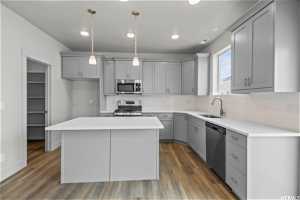 Kitchen with a kitchen island, stainless steel appliances, backsplash, sink, and dark hardwood / wood-style floors