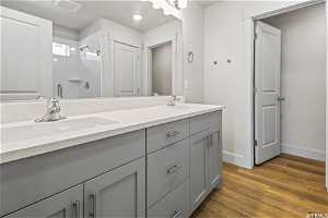 Bathroom with dual sinks, hardwood / wood-style flooring, and large vanity