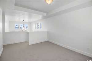 Unfurnished room with a chandelier and carpet flooring