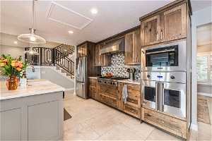 Kitchen featuring Viking  appliances with stainless steel finishes, tasteful backsplash, light tile floors, pendant lighting, and wall chimney exhaust hood