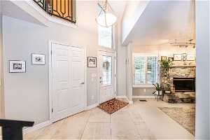 Entryway with rail lighting, a fireplace, and light tile floors