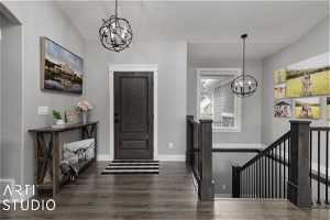 Entrance foyer featuring dark hardwood / wood-style flooring and an inviting chandelier