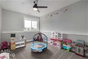 Playroom with dark carpet and ceiling fan