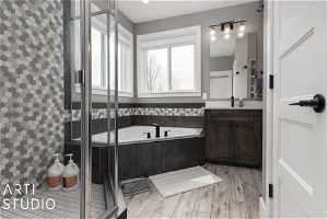 Bathroom featuring hardwood / wood-style floors, independent shower and bath, and vanity with extensive cabinet space