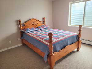 Carpeted bedroom featuring a baseboard radiator