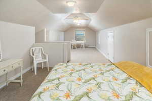 Carpeted bedroom featuring lofted ceiling and ceiling fan