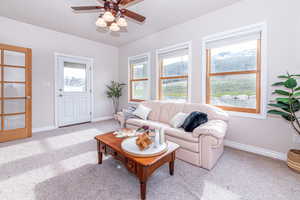 Carpeted living room with ceiling fan