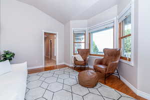 Living area with lofted ceiling and light tile floors