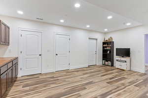 Living/Recreation room with light wood-type flooring, cabinets, and tons of storage