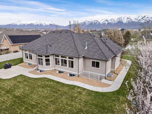 Back of house featuring a yard, a mountain view