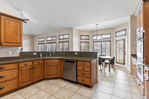 Kitchen featuring a chandelier, sink, a wealth of natural light, and dishwasher