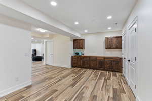 Living/Recreation room featuring dark brown cabinets and wood flooring with ample storage