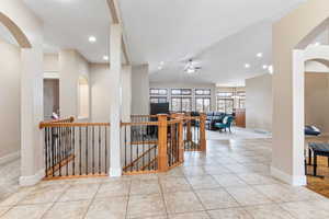 Corridor featuring light tile floors