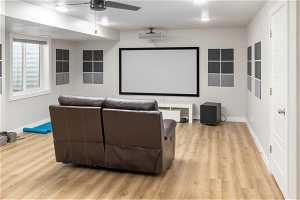 Cinema room featuring ceiling fan and light hardwood / wood-style floors