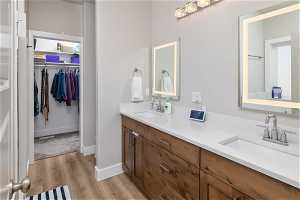 Bathroom with dual bowl vanity and hardwood / wood-style floors