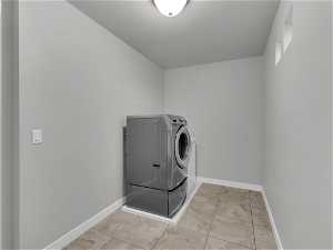 Laundry area with washer / clothes dryer and light tile flooring