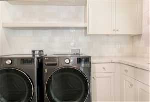 Laundry area featuring hookup for a washing machine, cabinets, and washer and clothes dryer