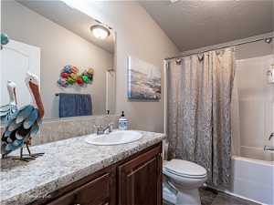 Full bathroom featuring toilet, vanity, and shower / tub combo with curtain
