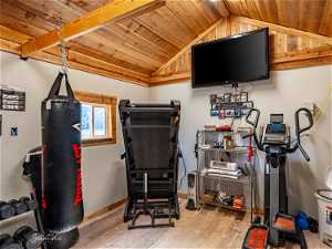 Workout room featuring light hardwood / wood-style flooring, vaulted ceiling, and wooden ceiling